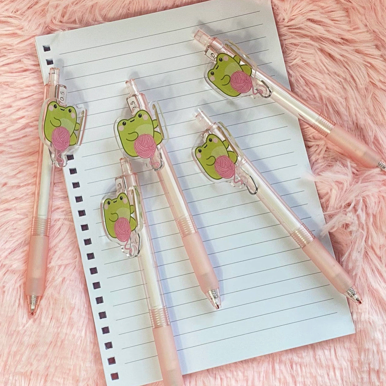 Frog Ballpoint pens laying on lined paper