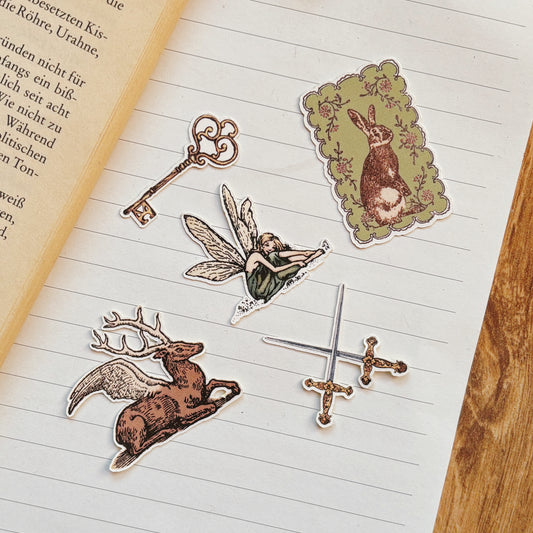 fairy themed sticker set 5 vintage fantasy stickers with fairy with wings winged deer bunny rabbit in sage frame skeleton key and crossed swords on a notebook page